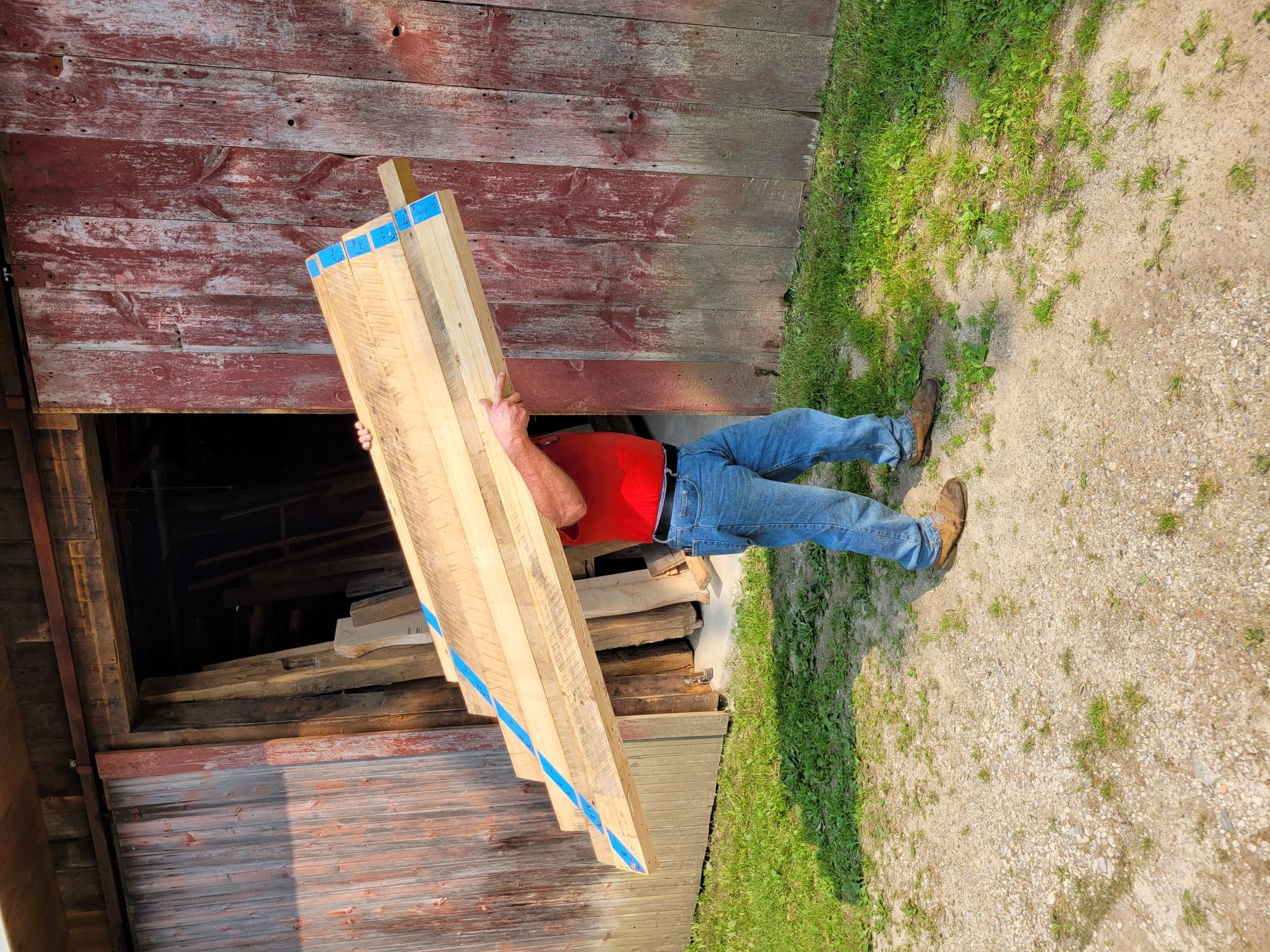 Jim carrying a countertop in front of his workshop