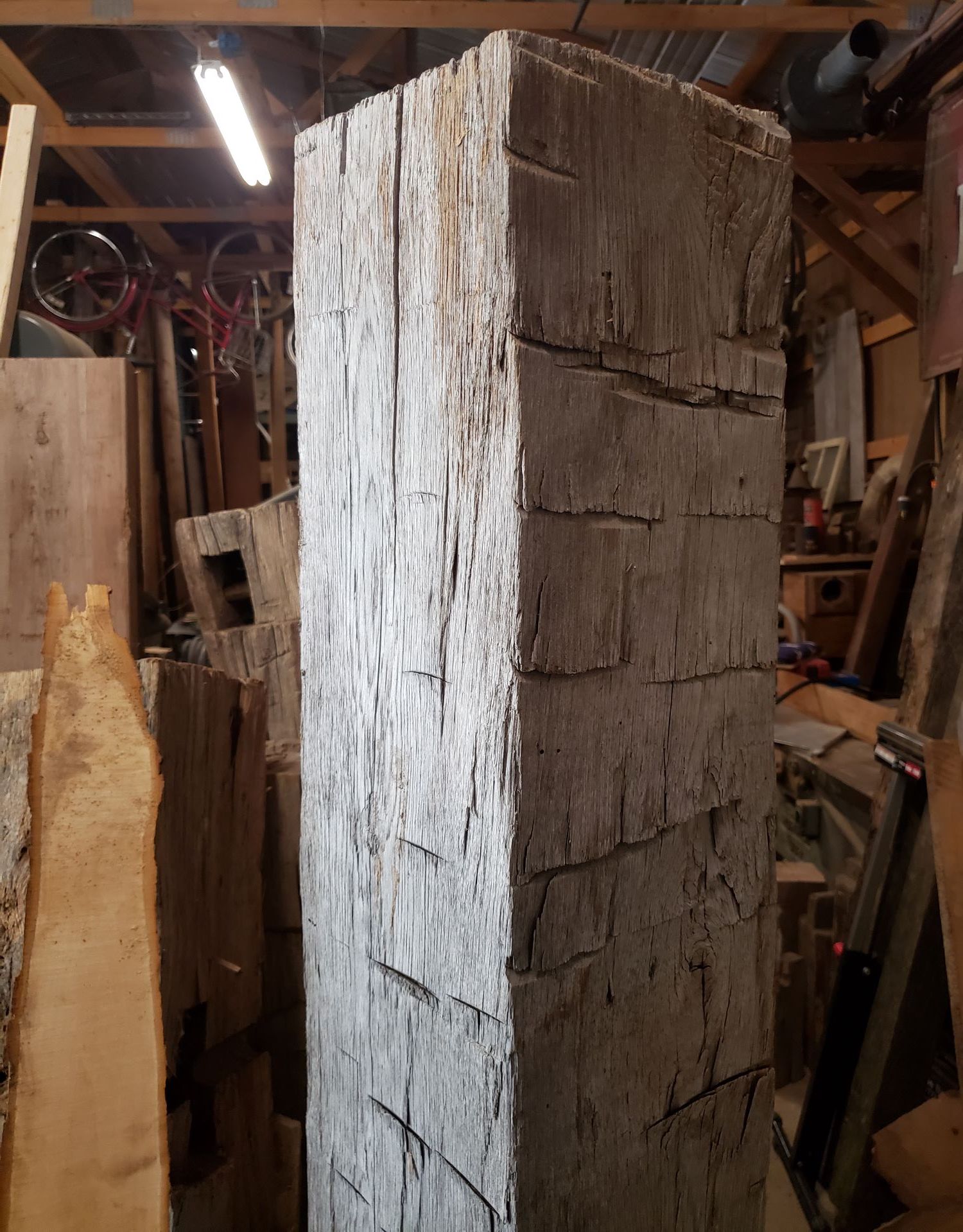 A hand hewn beam standing in our workshop
