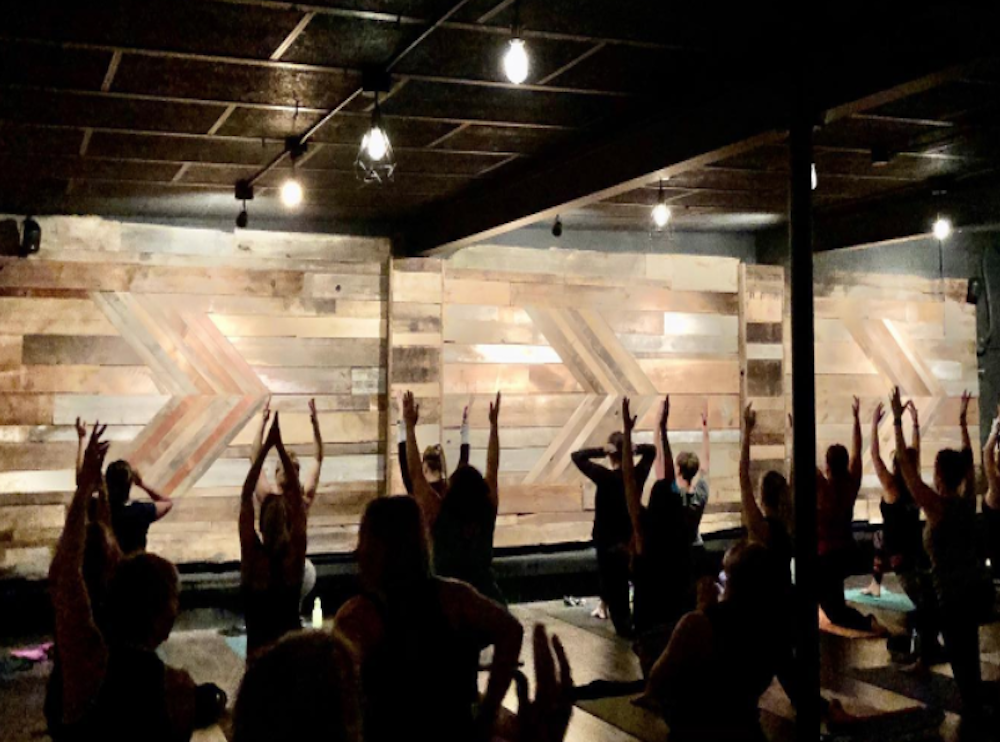 A photo of a yoga session being taught in front of the custom accent wall at White Buffalo