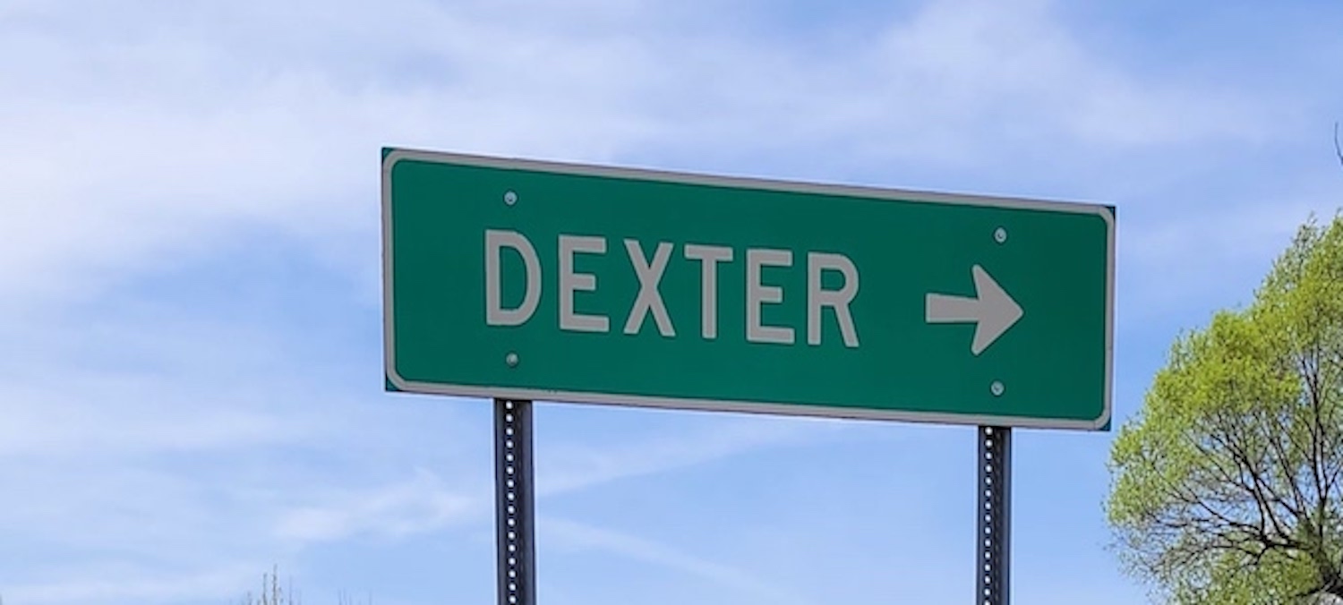 A close up of a highway sign for Dexter, MI