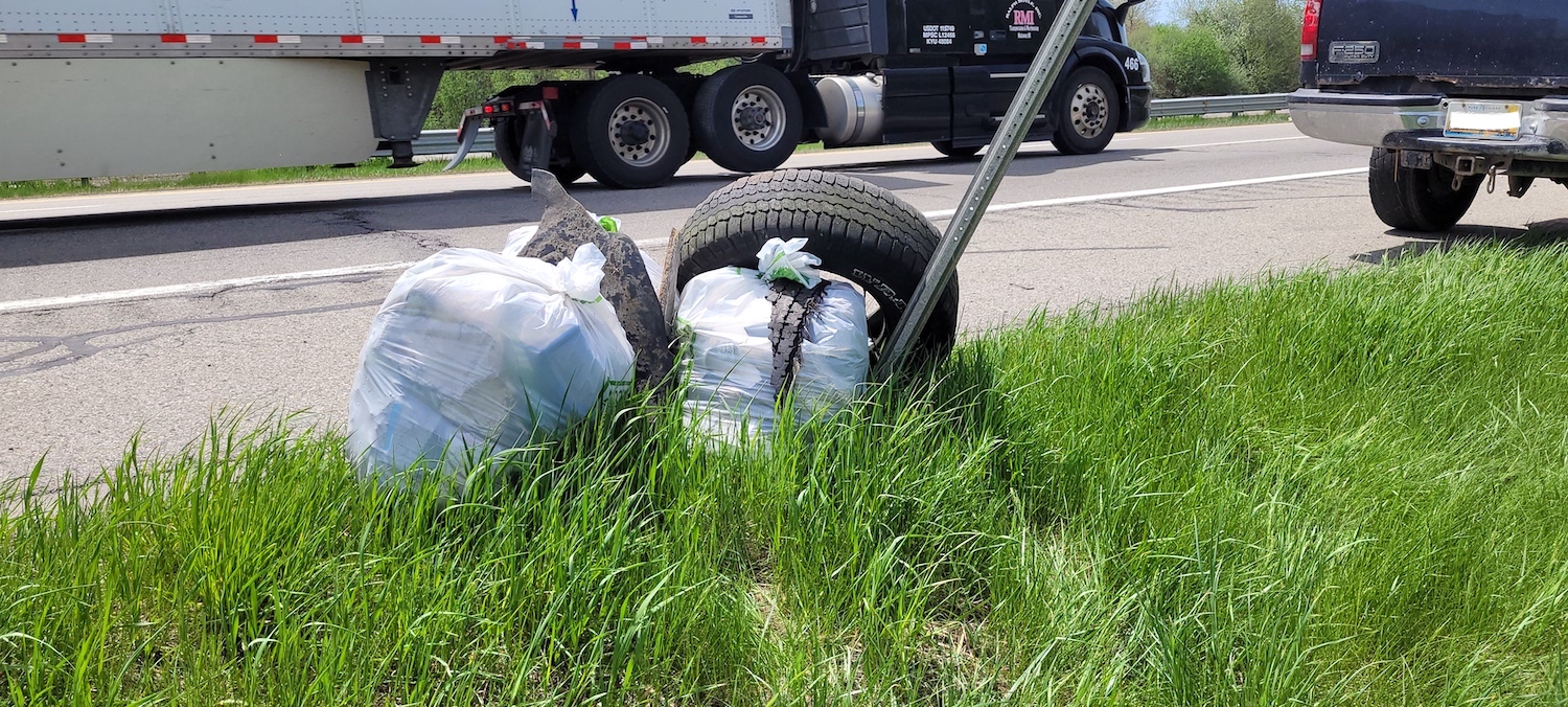 Bags of trash sitting on the side of the road from the Michigan Reclaimed Barns and Lumber trash pick up