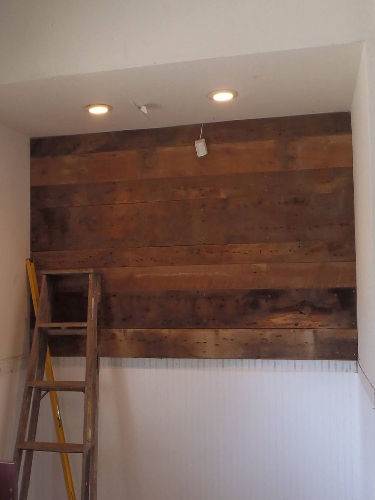 A brown reclaimed wood accent wall in an alcove