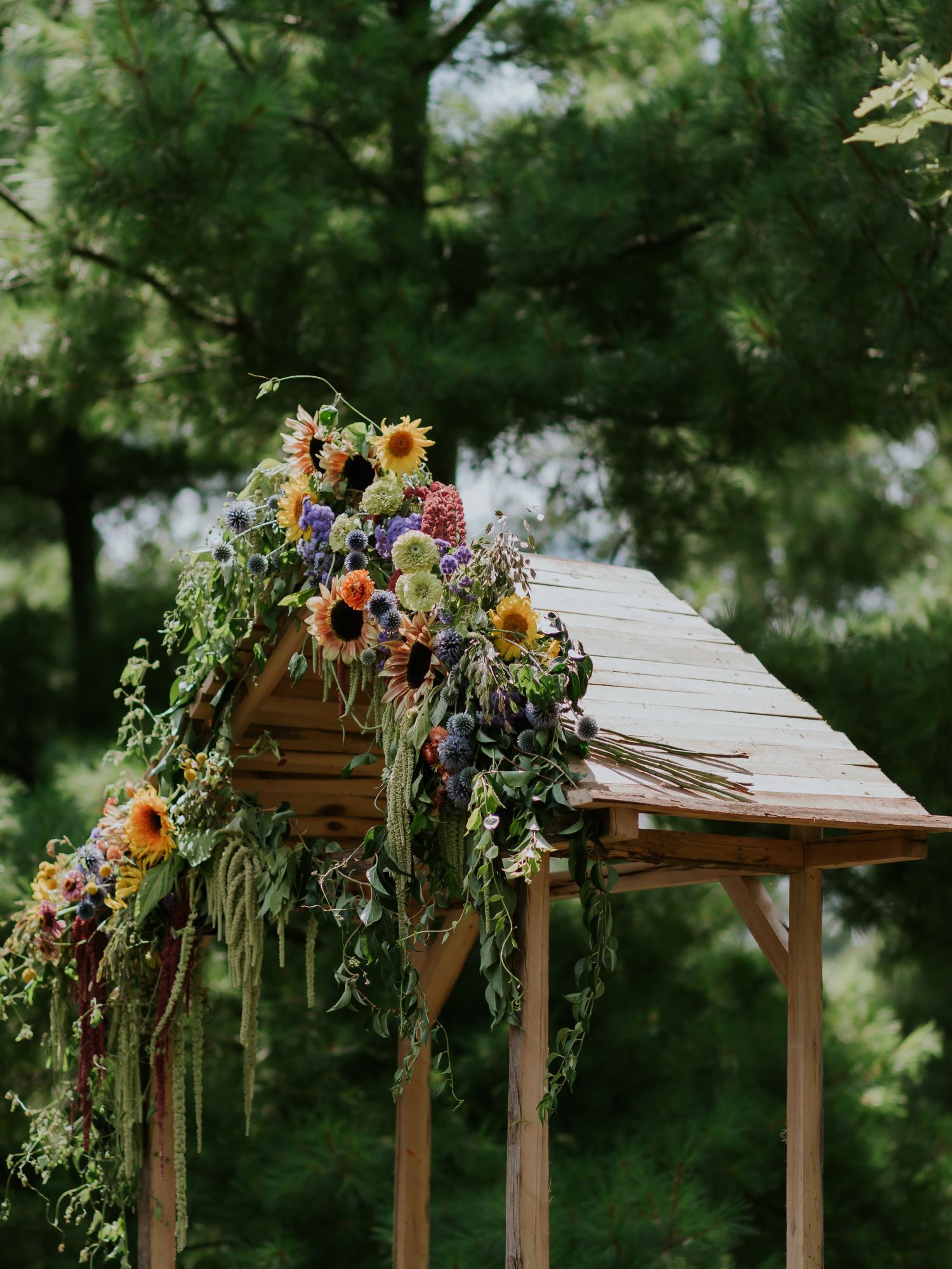 An arbor decorated with flowers for an ourdoor wedding
