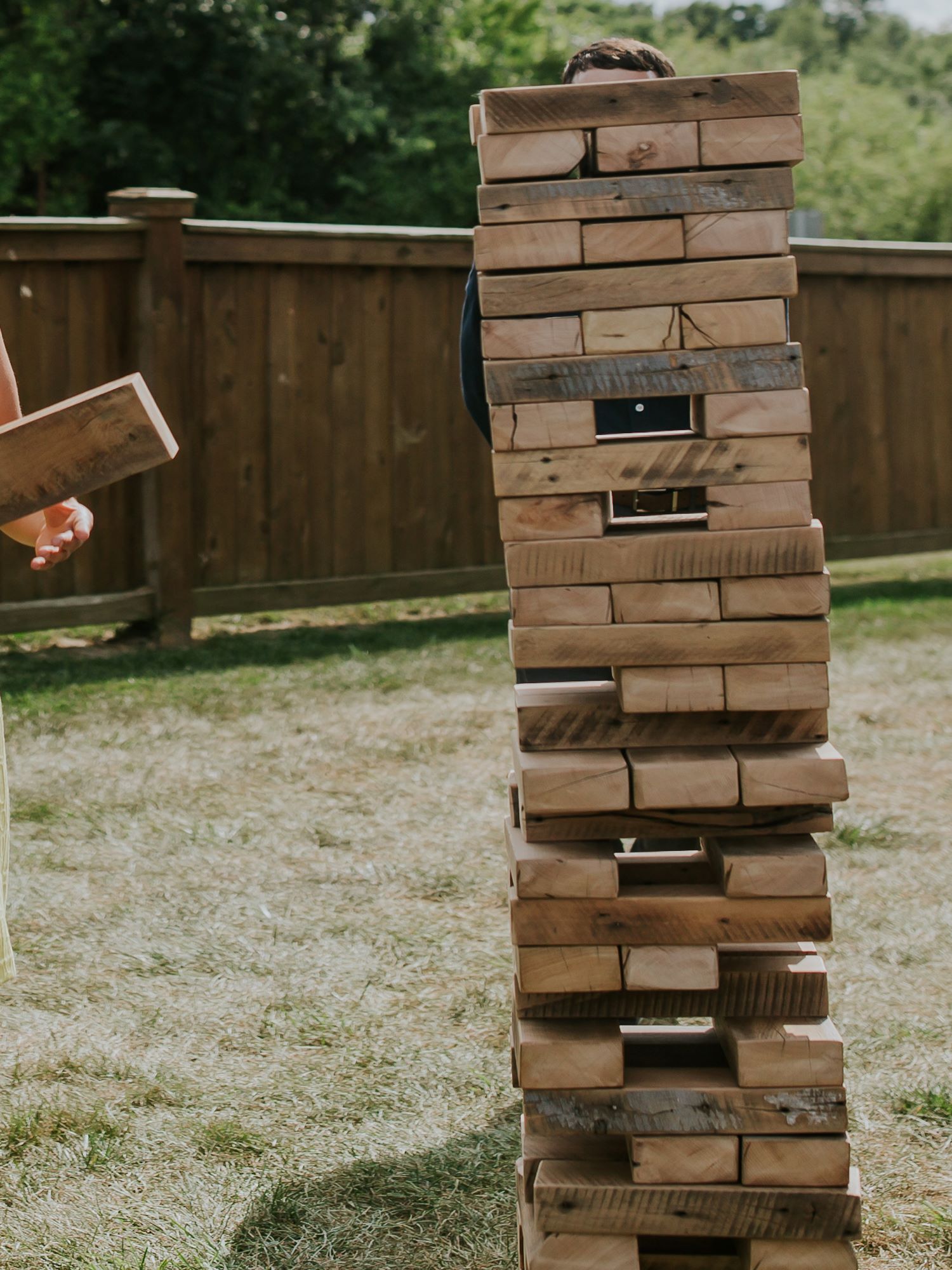 The giant jenga set being used at an outdoor wedding