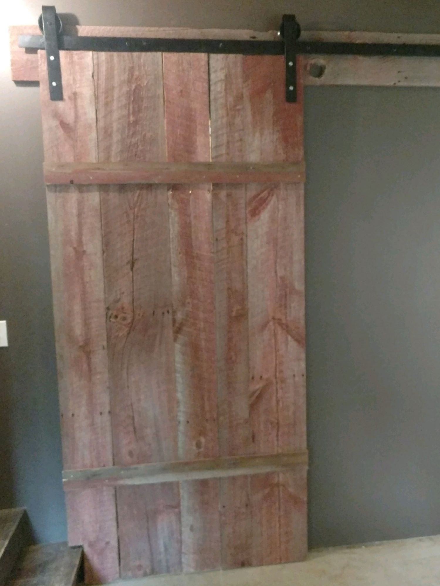 A red barnwood slider on a track in a customer's home