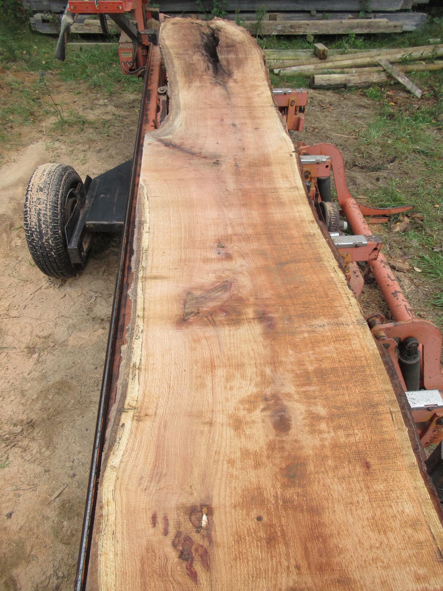 A live edge slab sitting on top of our red sawmill