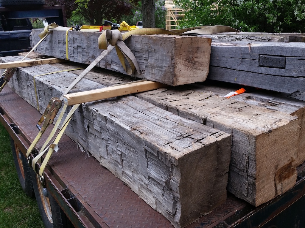 Hand-hewn barn beams loaded on the back of a pickup truck