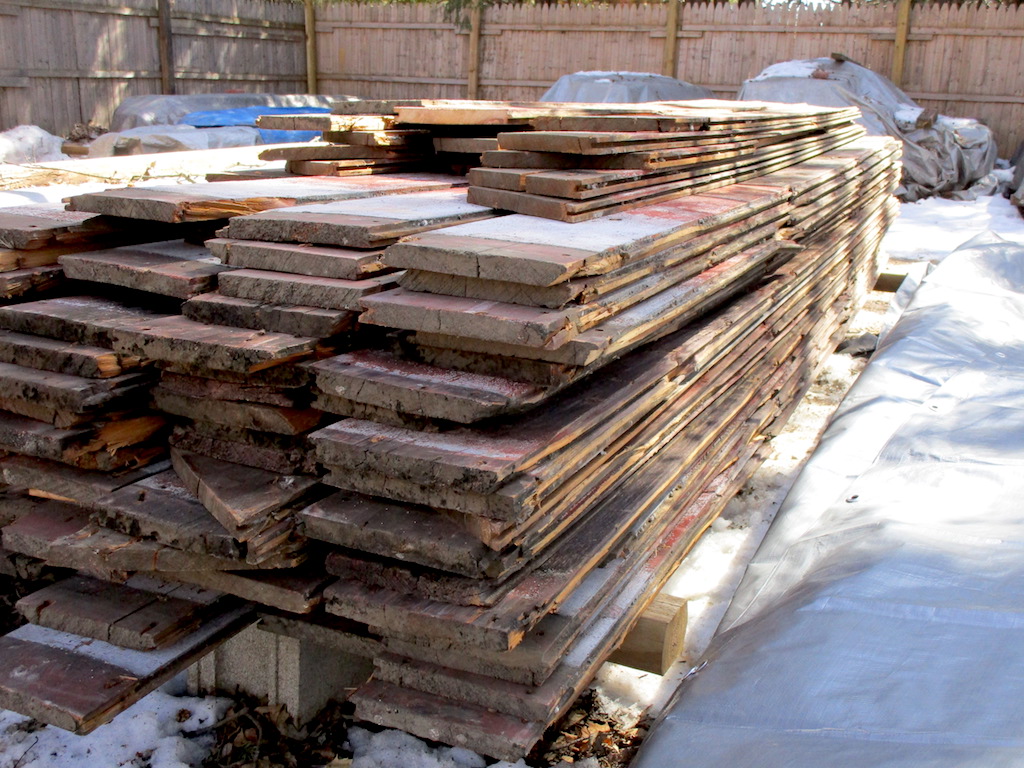 A stack of red planks sitting outside during a Michigan winter