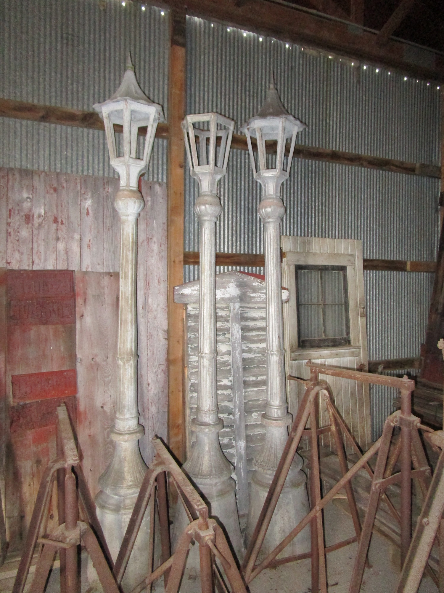A few antique, white streetlights lined up in a warehouse