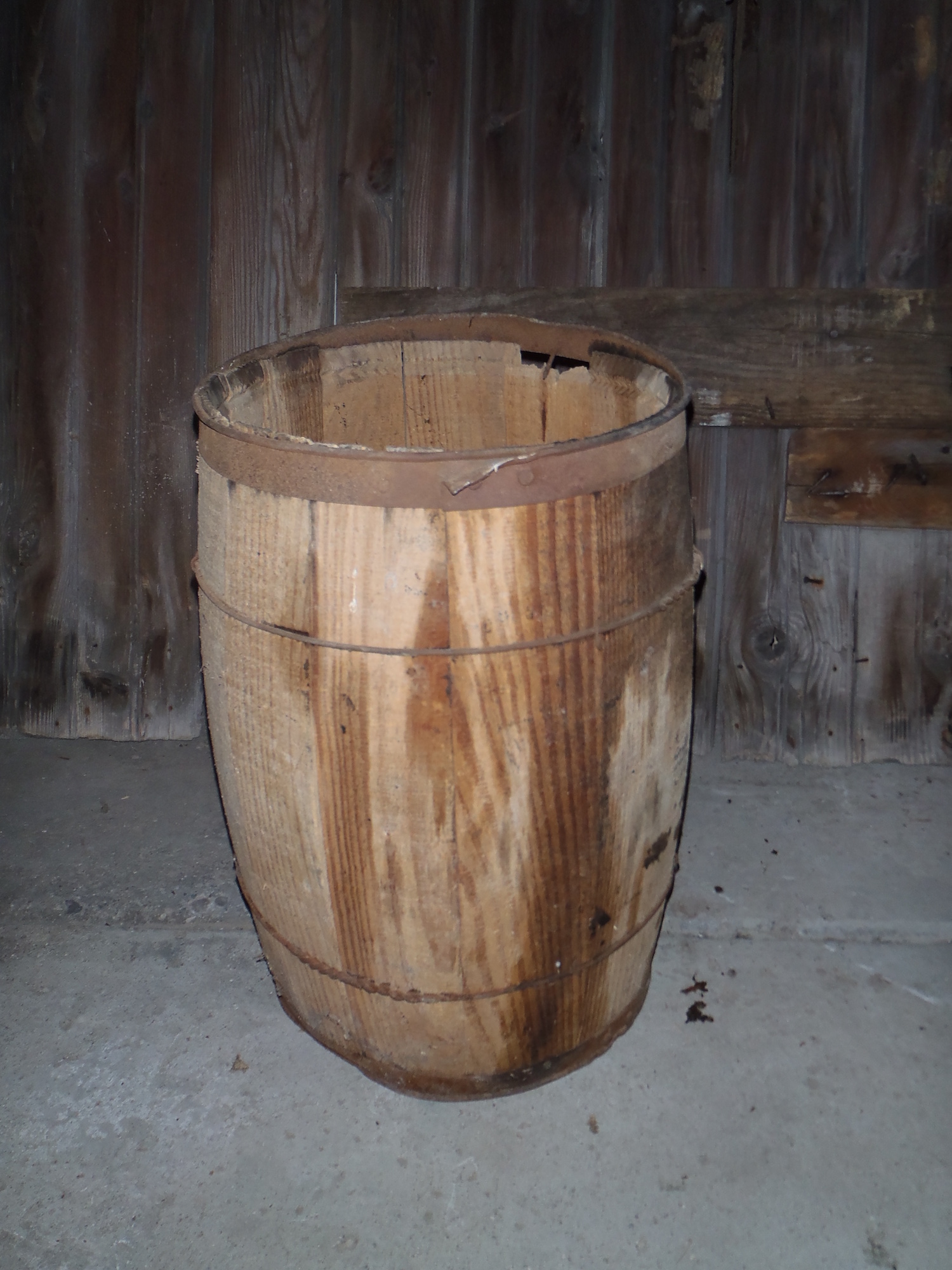 A wooden barrel salvaged from a barn deconstruction site