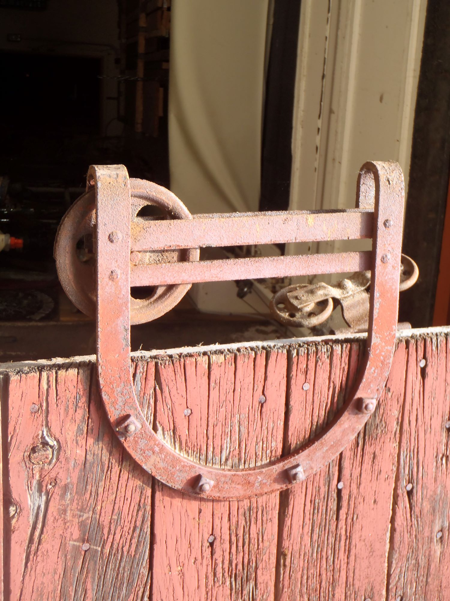 A forged iron bracket and roller wheel from a barn in St. John's, MI